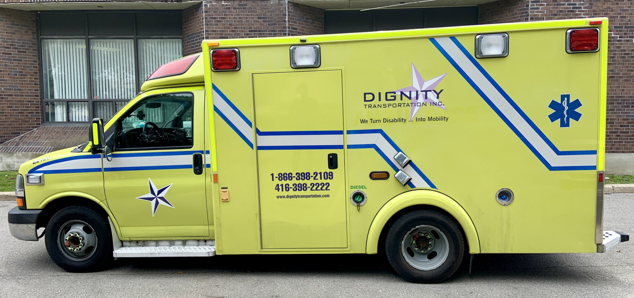 Dignity Transportation white accessible van parked in a hospital patient transfer zone