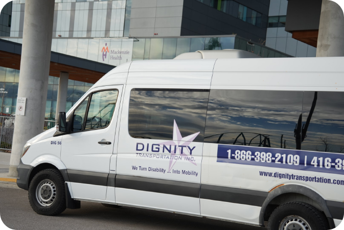 Dignity Transportation white wheelchair accessible shuttle parked in a safe accessible drop-off zone