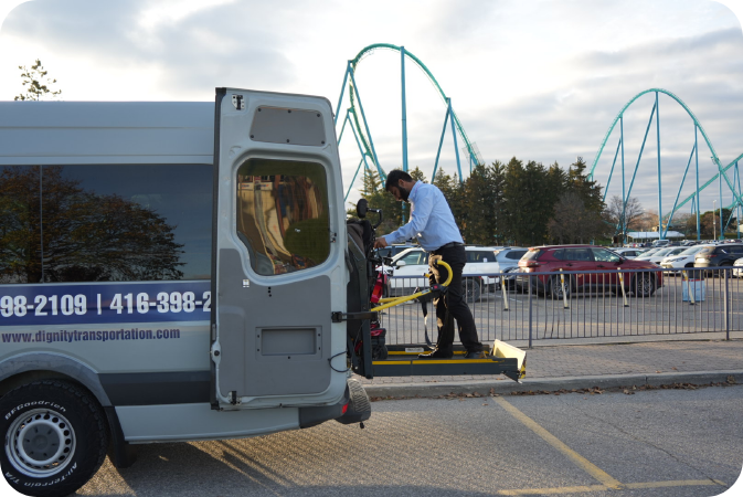 White wheelchair accessible van from Dignity Transportation with ramp deployed at a safe pickup location